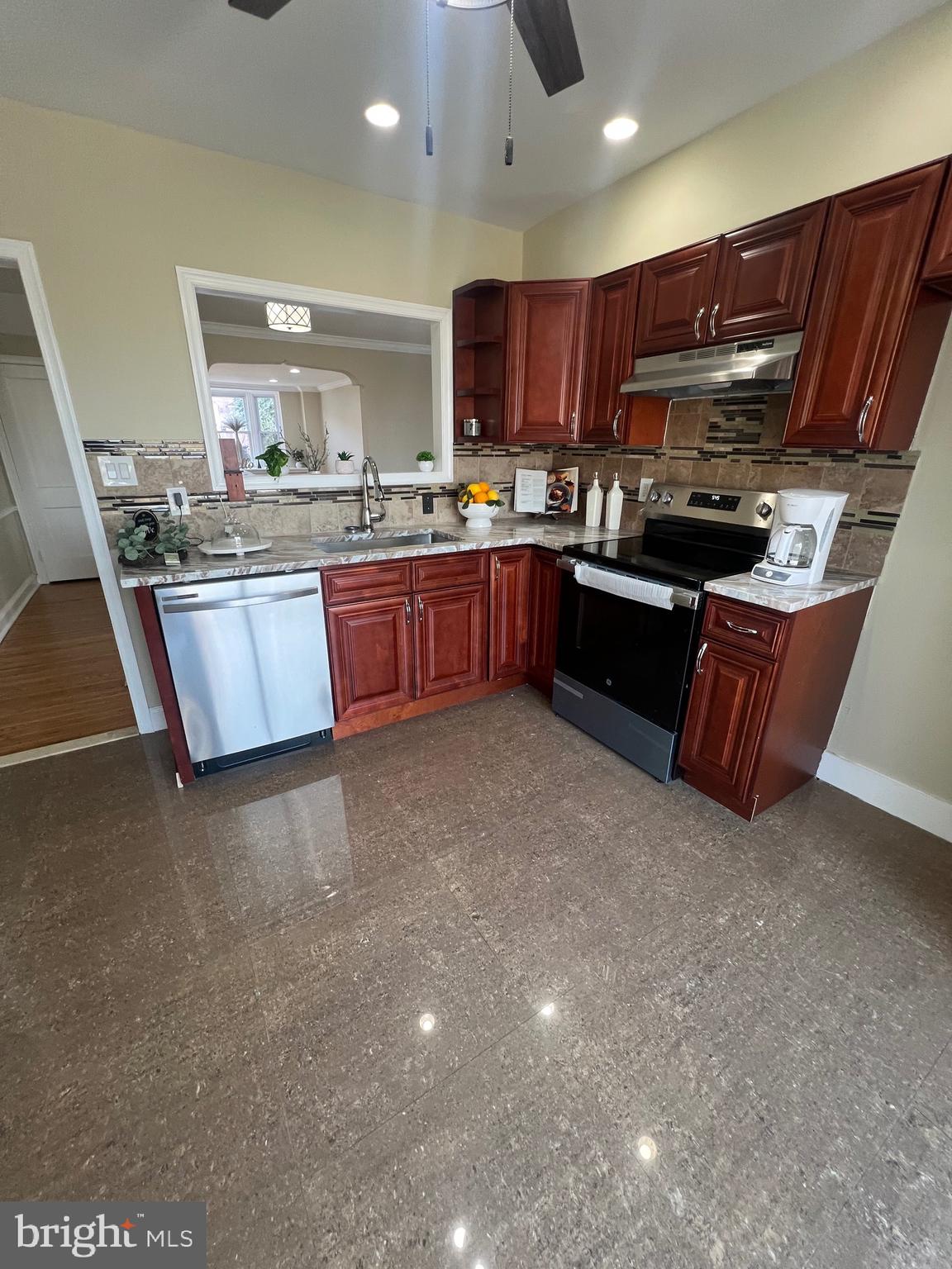 7975 Provident Street Philadelphia, PA 19150 - Photo 10 of 23 a kitchen with stainless steel appliances granite countertop a stove sink and cabinets
