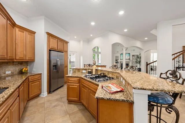 a kitchen with stainless steel appliances granite countertop a sink a stove and a refrigerator
