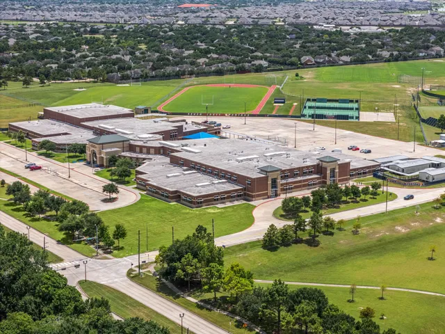 an aerial view of a house with a garden and lake view