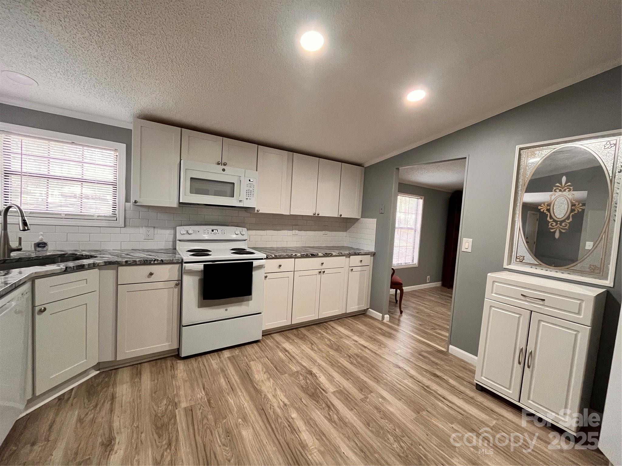 203 Shane Drive Mount Holly, NC 28120 - Photo 12 of 28 a kitchen with granite countertop white cabinets and white appliances