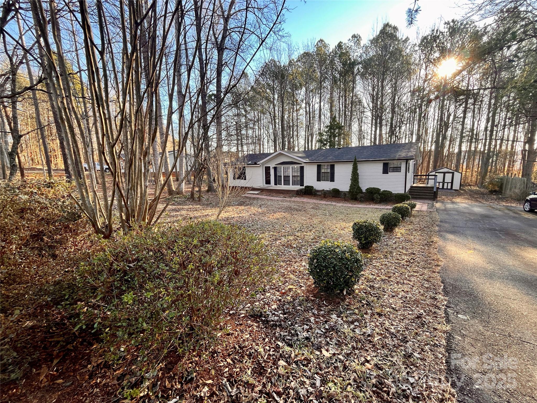 203 Shane Drive Mount Holly, NC 28120 - Photo 27 of 28 a house with trees in front of it