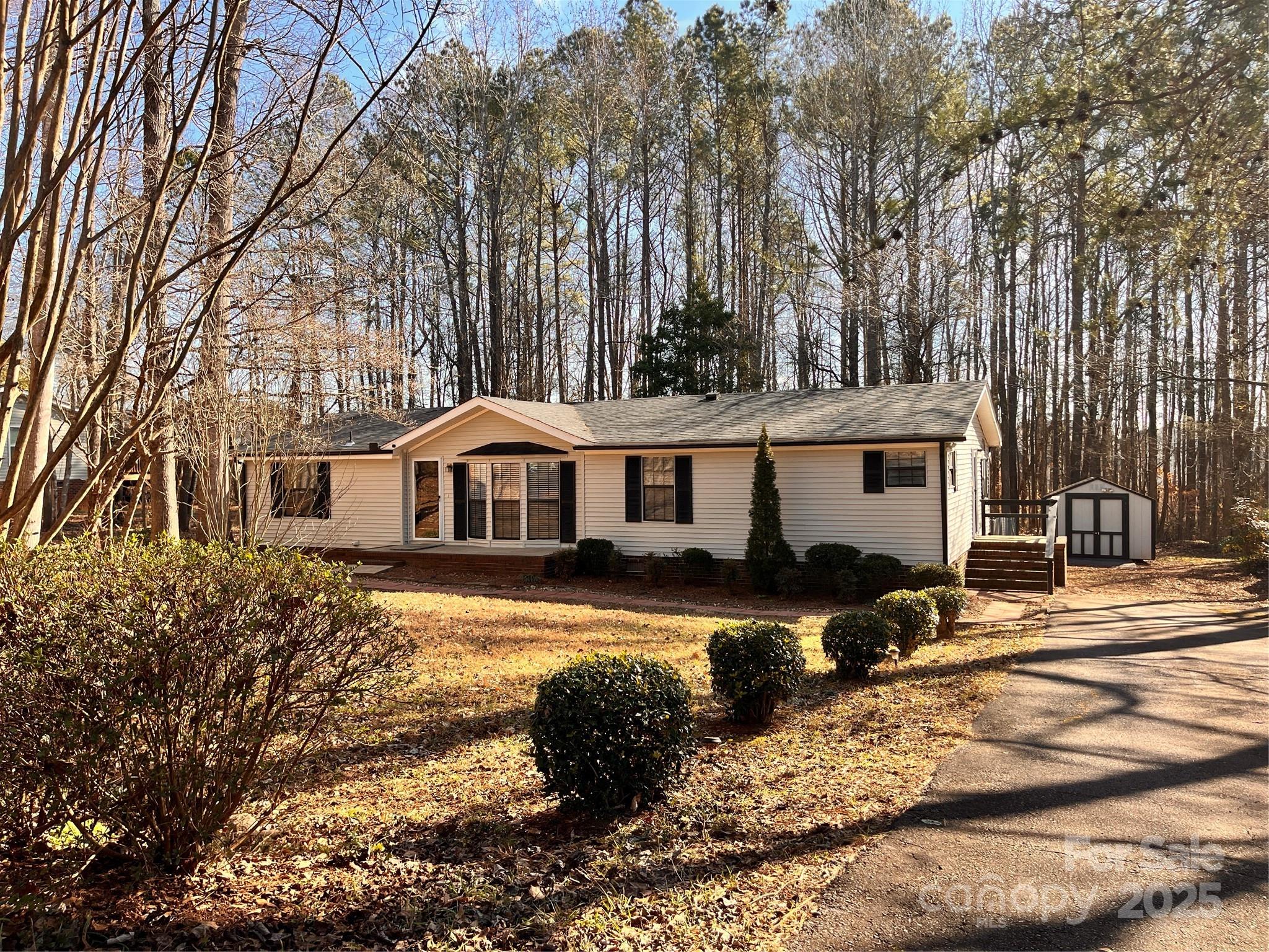 203 Shane Drive Mount Holly, NC 28120 - Photo 28 of 28 a front view of a house with a yard covered with snow and trees