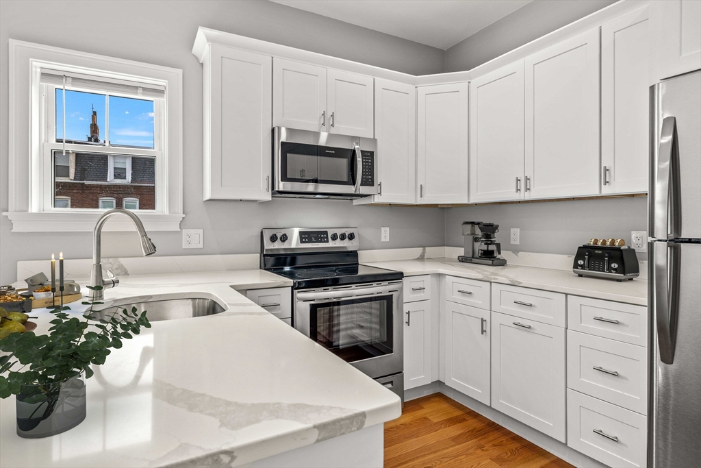 a kitchen with stainless steel appliances white cabinets a sink and dishwasher