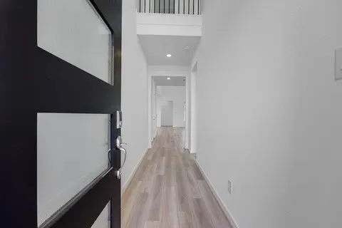 a view of a hallway with wooden floor and staircase