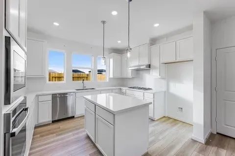 a kitchen with a sink window and stainless steel appliances