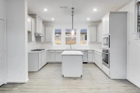 a kitchen with white cabinets and appliances