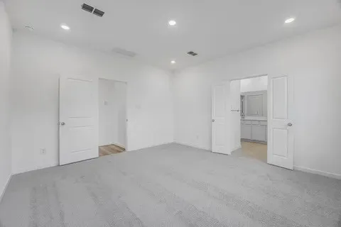 an empty room with an entryway and fan