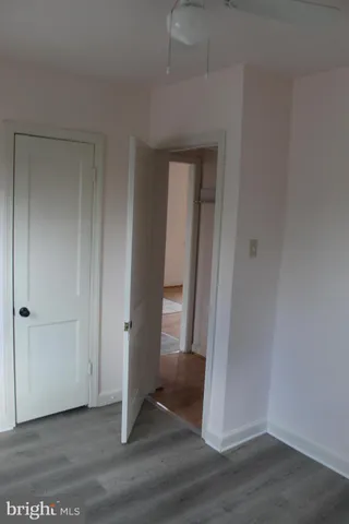 an empty room with wooden floor and entrance