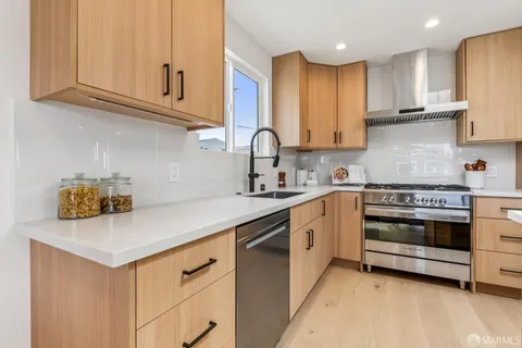a kitchen with stainless steel appliances a stove a sink and cabinets