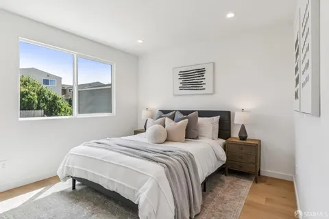 a bedroom with a bed and a large window