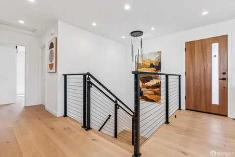 a view of entryway and hall with wooden floor