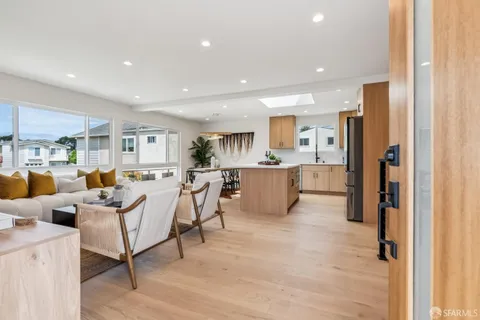 a living room with lots of furniture and kitchen view