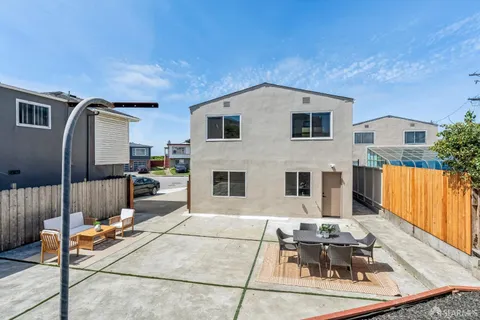 a view of a house with backyard and sitting area