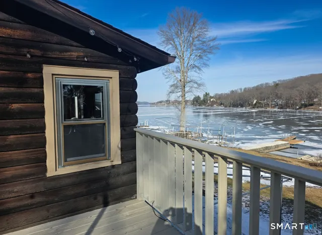 a front view of a house with a large tree