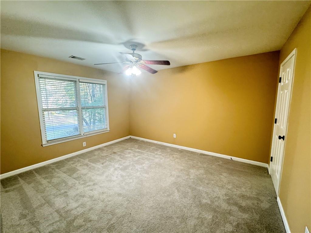 2550 Wellsley Lane Cumming, GA 30041 - Photo 16 of 19 an empty room with windows and chandelier fan
