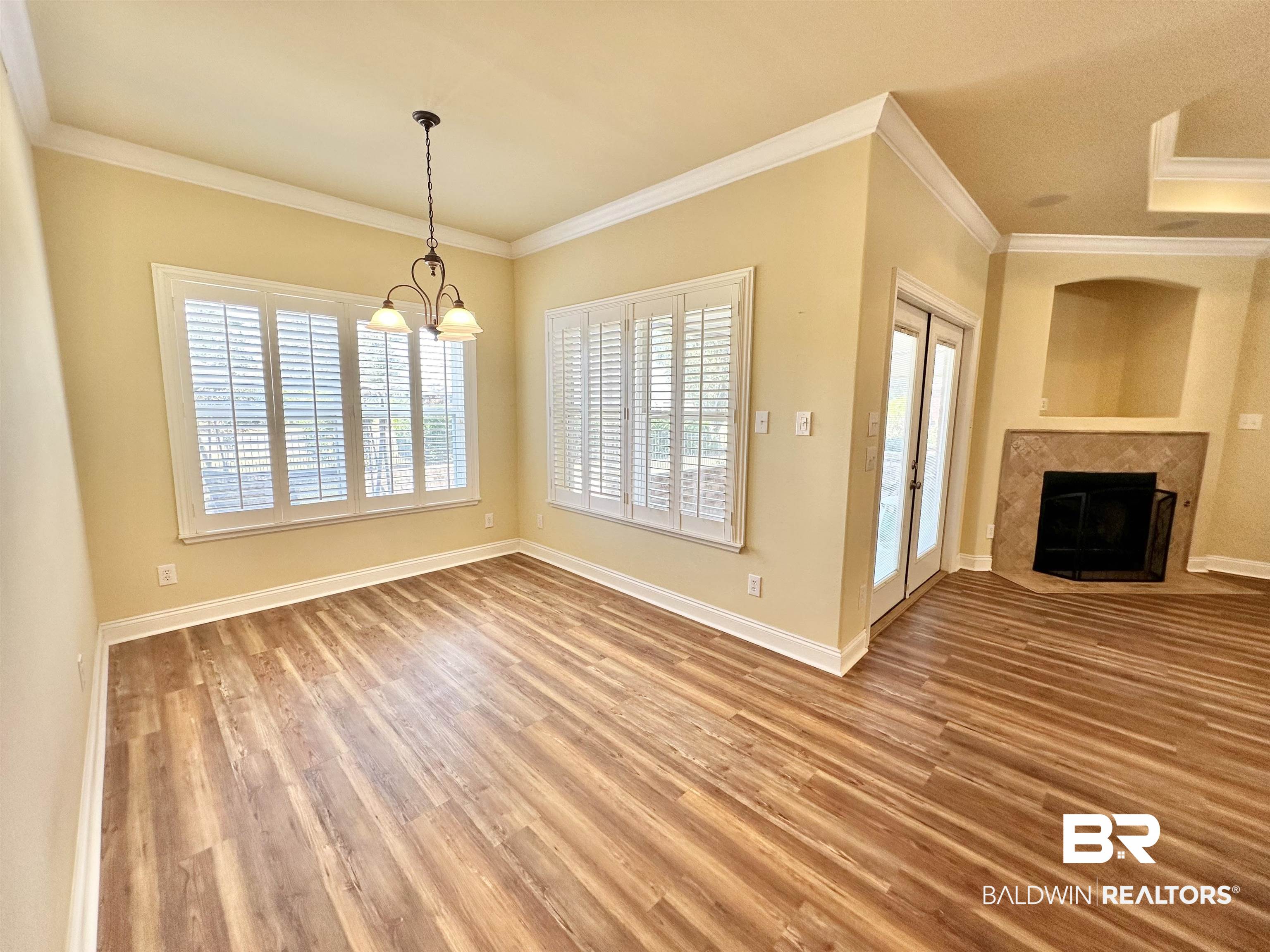 249 Hemingway Loop Foley, AL 36535 - Photo 7 of 33 Unfurnished dining area with hardwood / wood-style flooring, ornamental molding, and an inviting chandelier