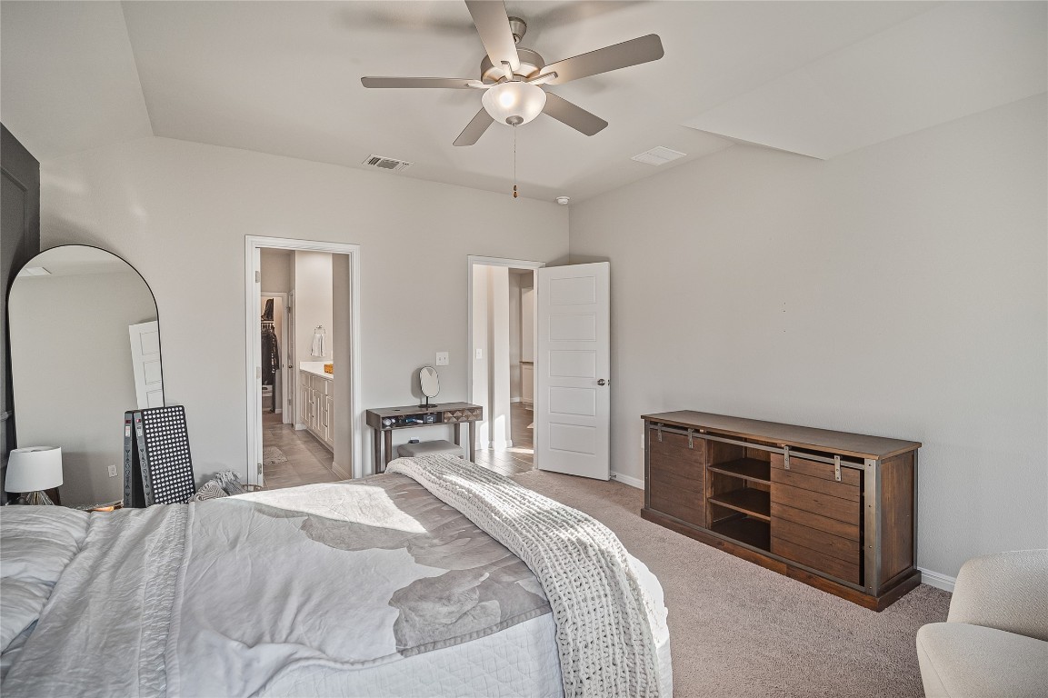 9905 Comely Bend Manor, TX 78653 - Photo 14 of 22 Bedroom with ceiling fan, carpet, and connected bathroom
