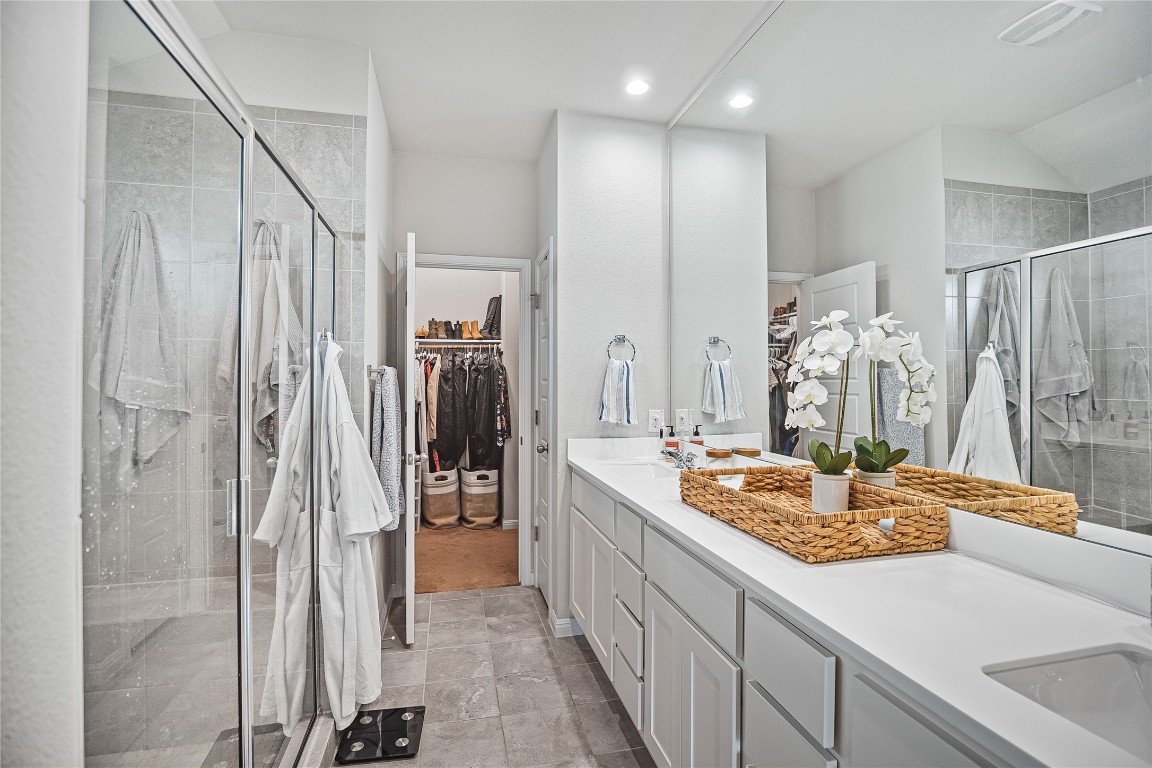 9905 Comely Bend Manor, TX 78653 - Photo 16 of 22 Bathroom featuring a spacious closet, a stall shower, and double vanity