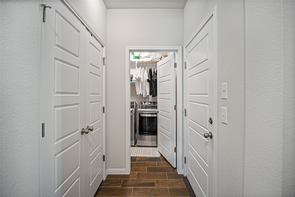 9905 Comely Bend Manor, TX 78653 - Photo 8 of 22 Corridor with wood finish floors, washing machine and dryer, and a textured wall