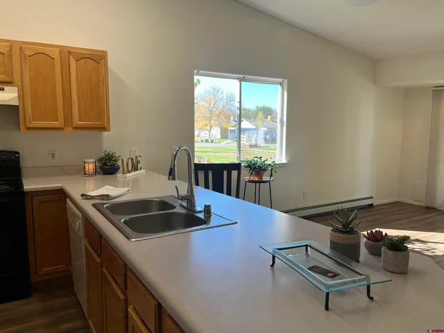 a kitchen with stainless steel appliances a stove a sink a refrigerator and wooden floor