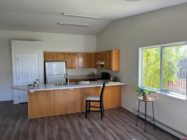 a view of a workspace with wooden floor and a sink