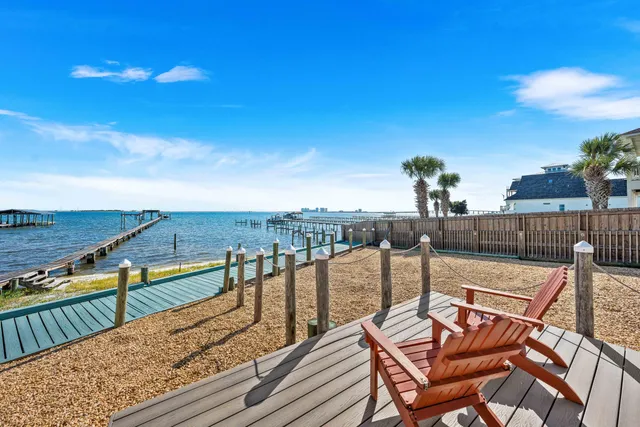 a living room with furniture kitchen view and a chandelier