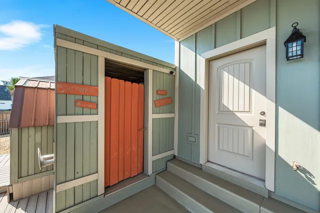 a bedroom with a bed a dresser and wooden floor