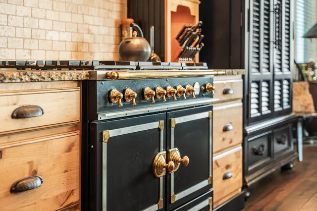 a kitchen with granite countertop a sink a stove and cabinets