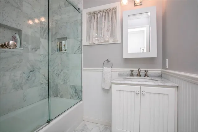 a bathroom with a granite countertop sink a toilet and a shower