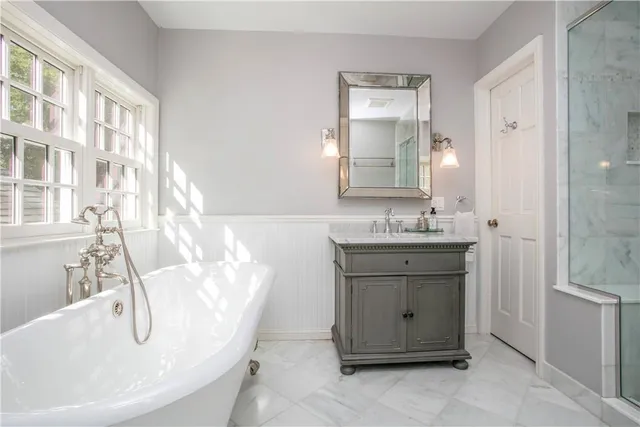 a bathroom with a double vanity sink mirror and bathtub