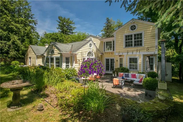 a front view of a house with a yard street and fountain