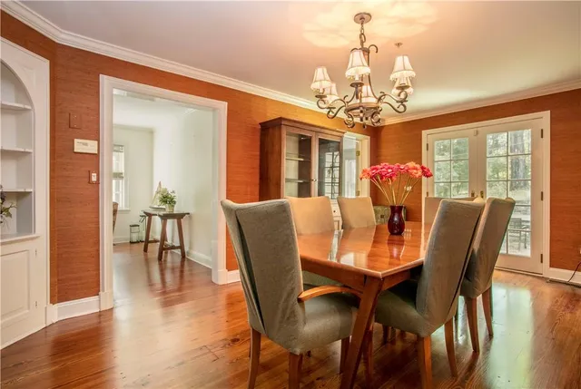 a view of a dining room with furniture a chandelier and wooden floor