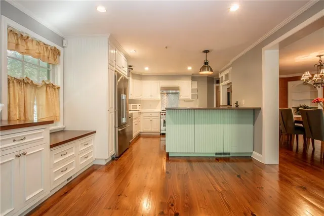 a view of a kitchen with wooden floor and electronic appliances