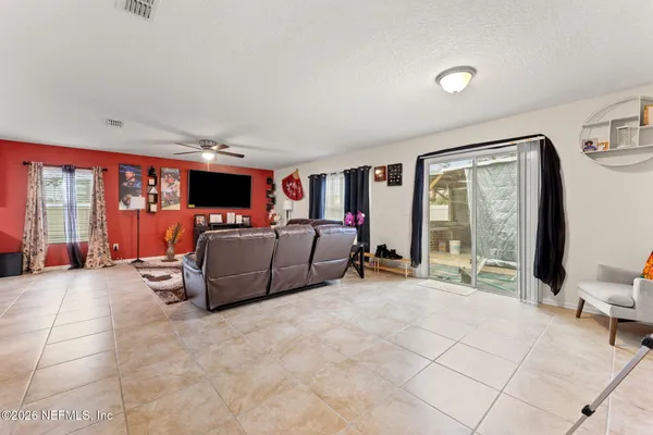 a living room with furniture a flat screen tv and a large window