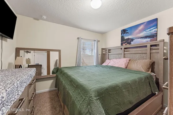 a bedroom with a large bed and flat screen tv