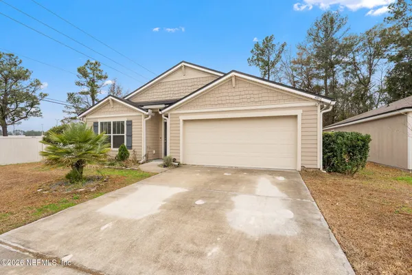 a view of a house with a yard and potted plants