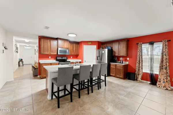 a view of kitchen with stainless steel appliances granite countertop a table and chairs