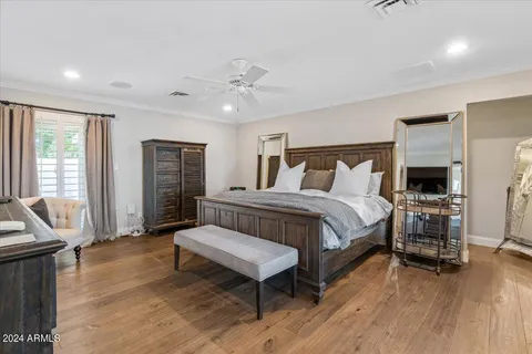 a bedroom with a bed a flat screen tv and a chandelier