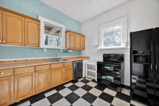 a kitchen with stainless steel appliances a stove a sink and a refrigerator