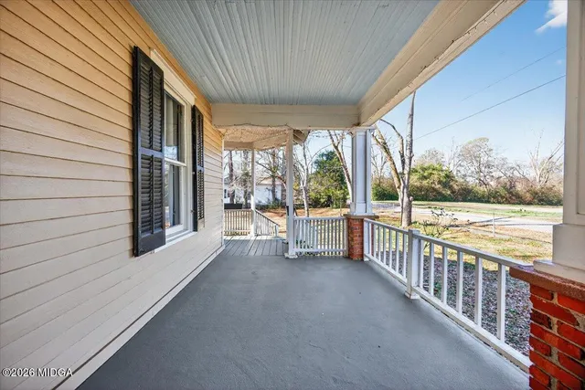 a view of a room with wooden floor and iron stairs