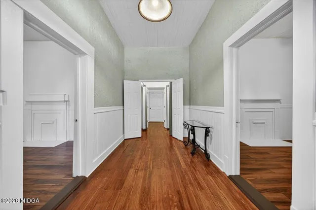 a view of a hallway with wooden floor and staircase