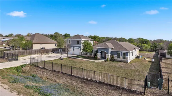 a view of a house with a big yard and large trees