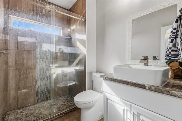 a living room with stainless steel appliances furniture a rug and a kitchen view