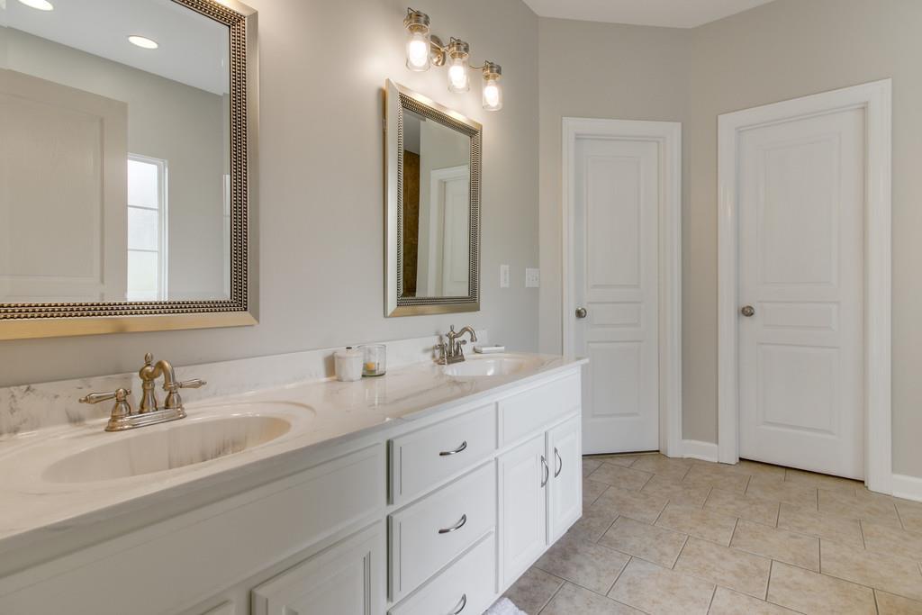 1002 Hallcrest Road Burns, TN 37029 - Photo 16 of 30 a bathroom with double vanity sinks and a mirror
