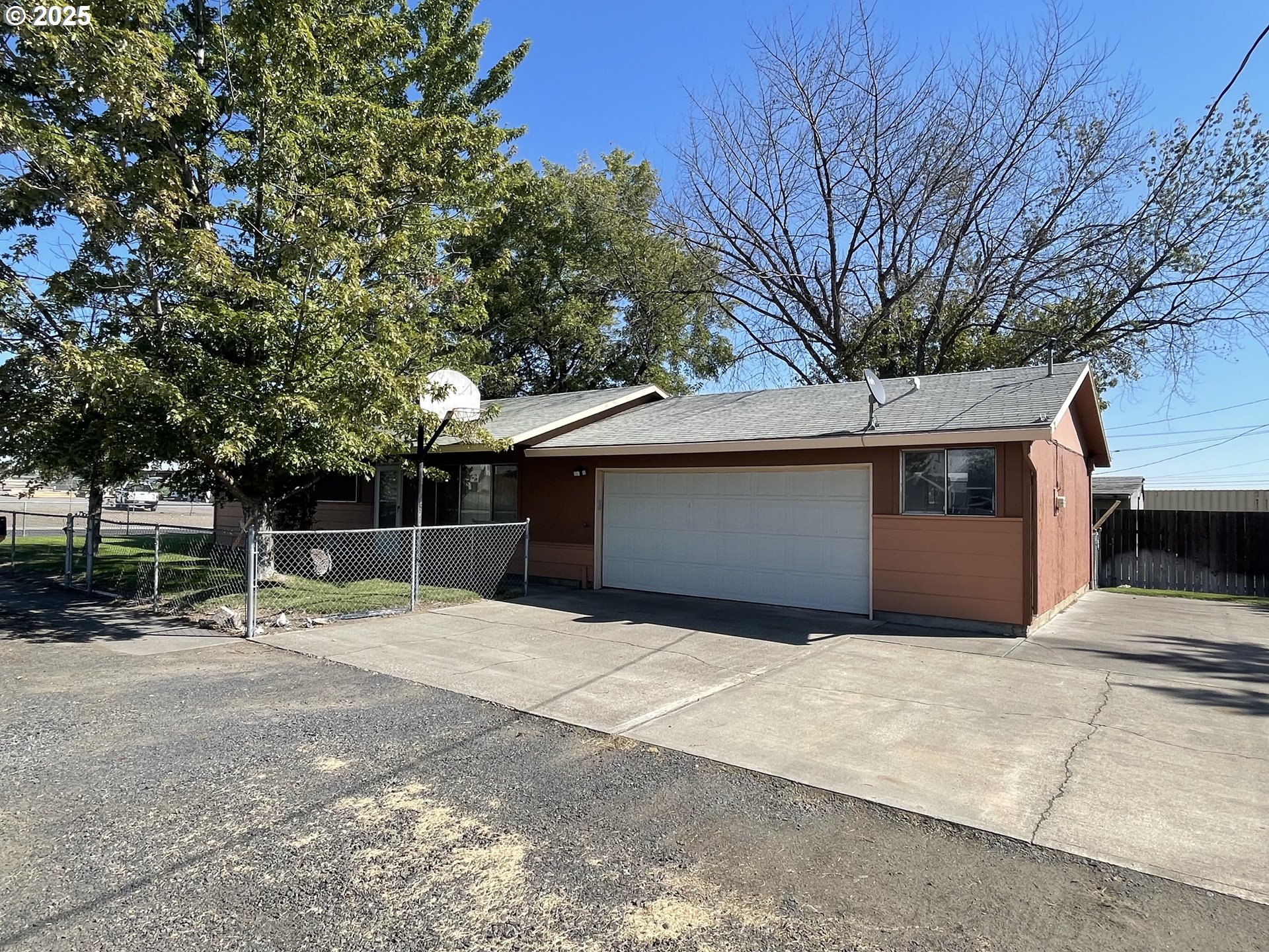 490 Northwest 3rd Street Hermiston, OR 97838 - Photo 13 of 15 a backyard of a house with large trees and a barn