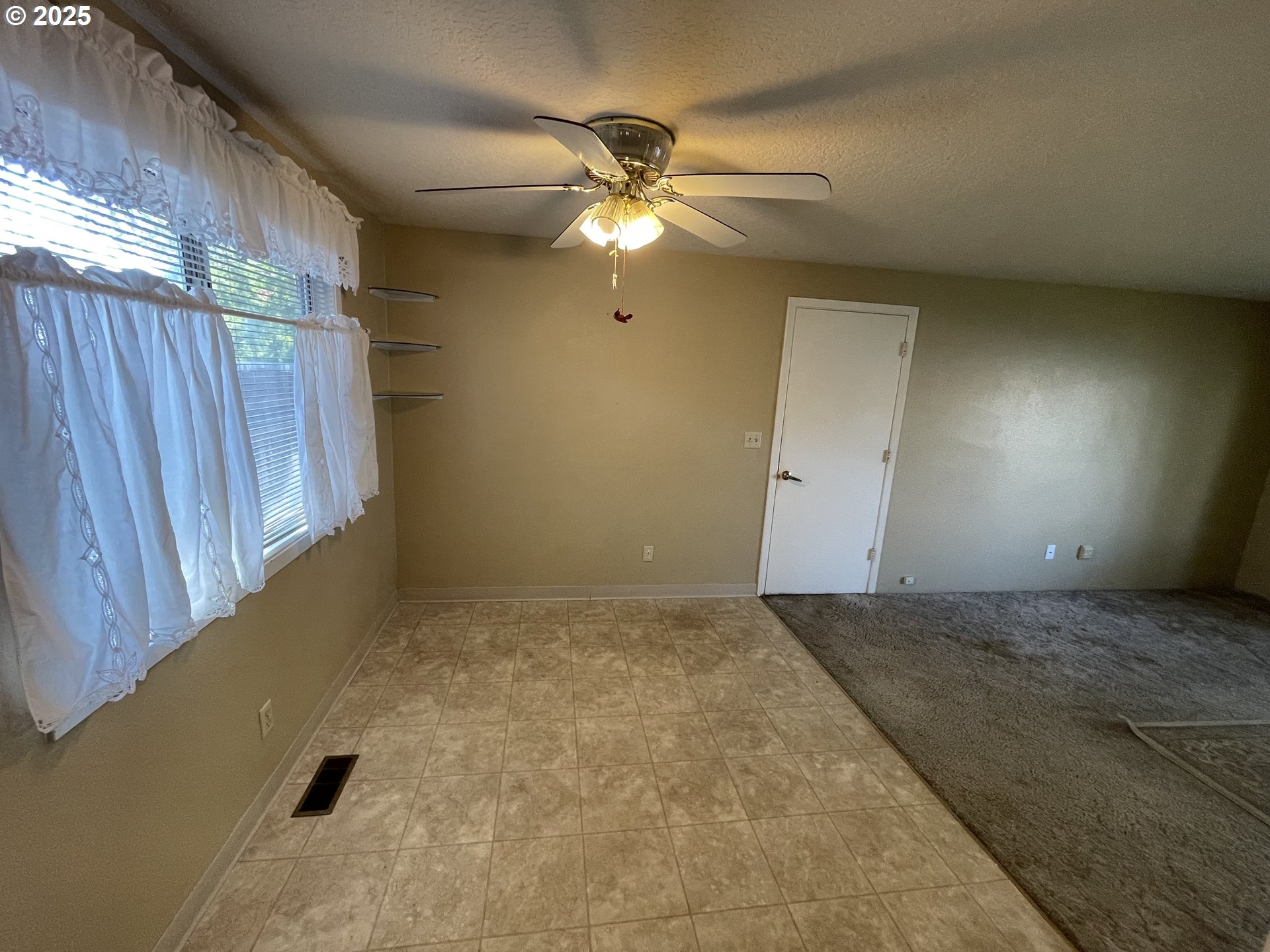 490 Northwest 3rd Street Hermiston, OR 97838 - Photo 5 of 15 a view of an empty room with a ceiling fan and window