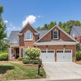 a view of a house with a yard and potted plants