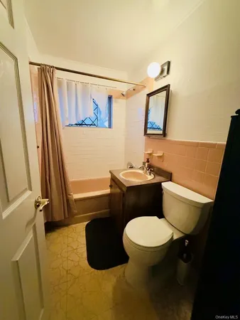 a bathroom with a granite countertop sink mirror vanity and toilet