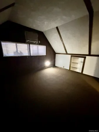 a view of an empty room with wooden floor and windows