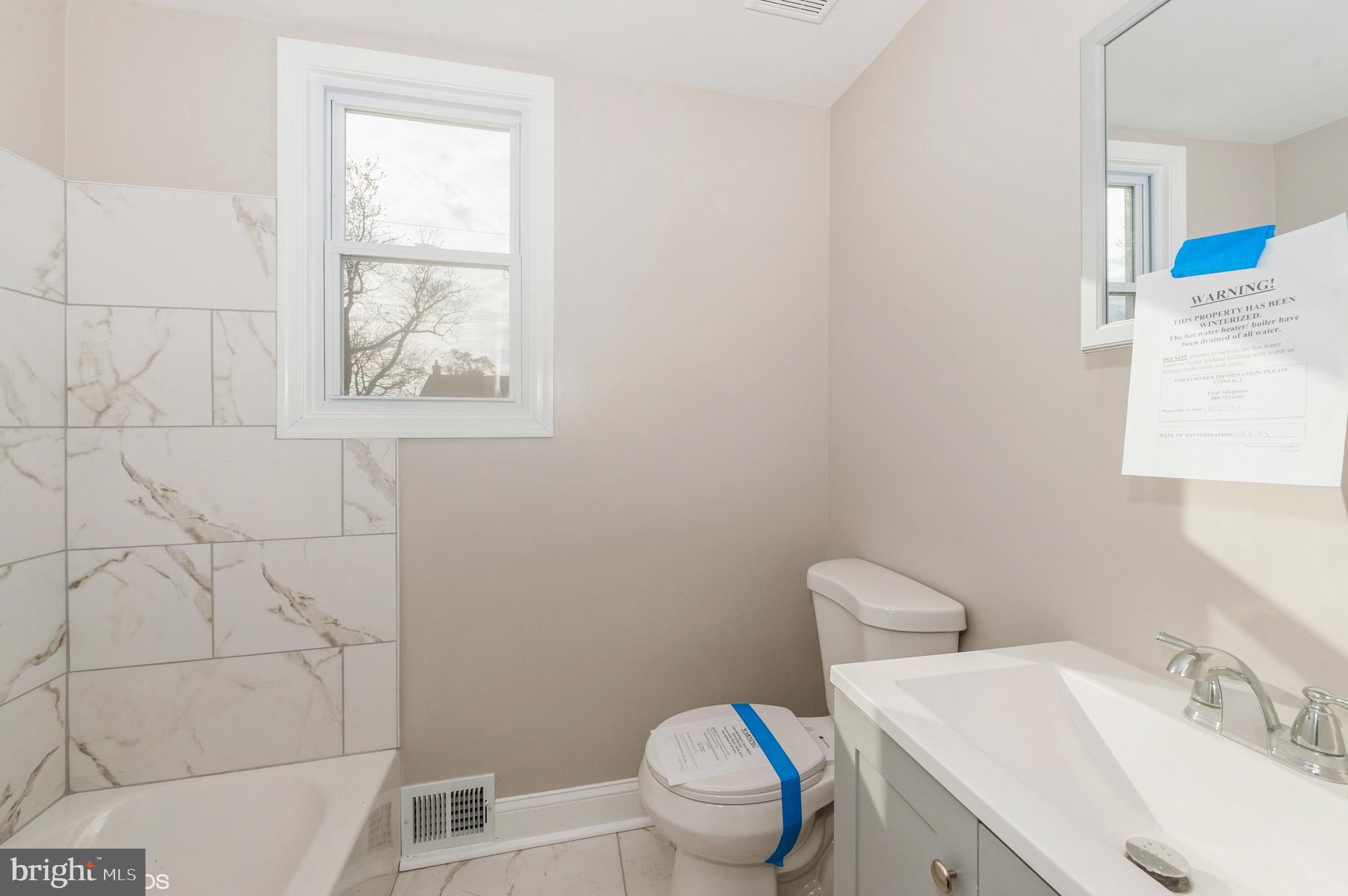 6236 The Alameda Baltimore, MD 21239 - Photo 13 of 15 a white toilet sitting next to a bathroom sink